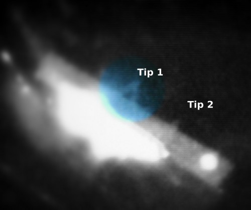  AFM tip as seen through magnifying optics on a screen - the glow of an infrared laser is visible as bright, white spot beneath the barely visible tips